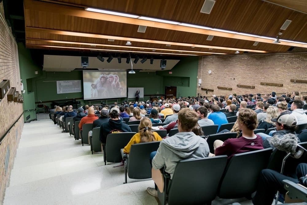 A packed auditorium listening to Sura