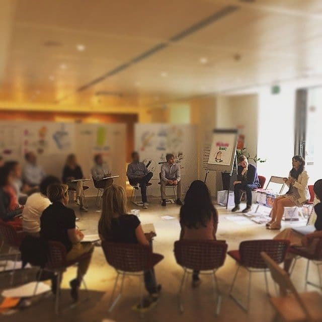 Sura leading a live session with a seated group