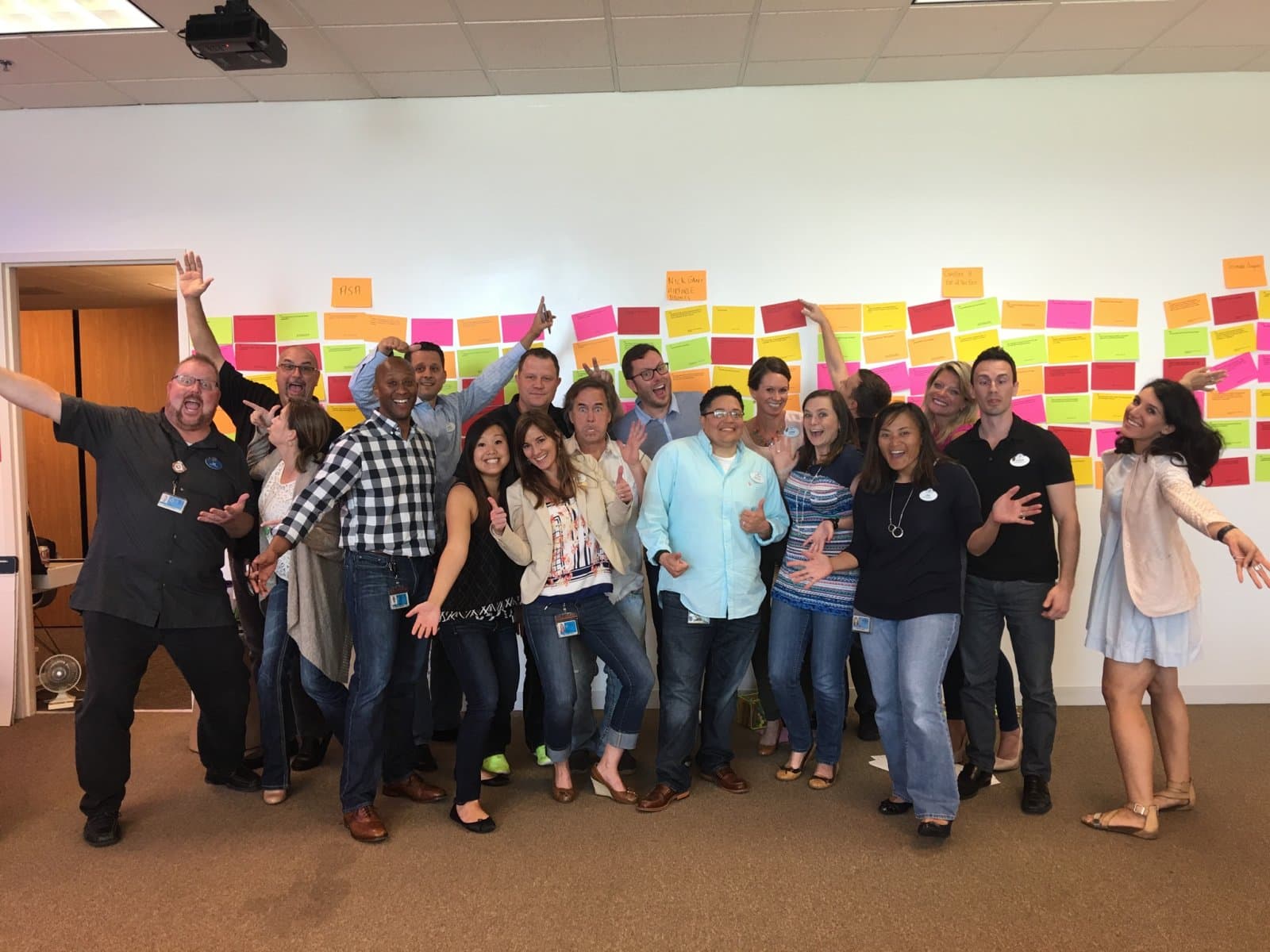 A cheering team posing in front of their idea wall